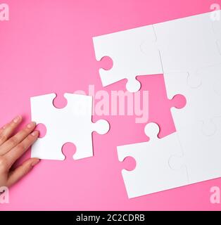 Femme place de grandes énigmes blanc sur fond rose, un élément manquant, vue d'en haut Banque D'Images