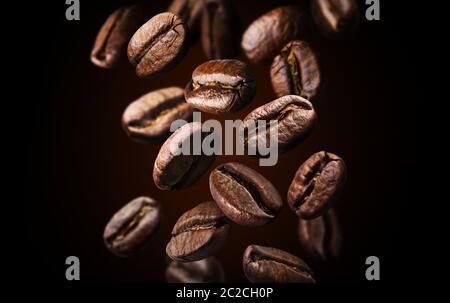 Roasted Coffee beans qui tombent ou qui volent sur fond noir, Close up, texture marron Banque D'Images