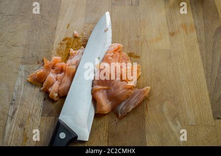 Trancher le saumon fumé frais sur une planche à découper en bois avec un  couteau de cuisine Photo Stock - Alamy