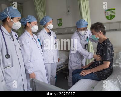 (200617) -- WUHAN, 17 juin 2020 (Xinhua) -- le docteur Yang Chengqing (2e, R) vérifie les conditions de Hu Dingjiang dans une salle de l'hôpital pulmonaire de Wuhan à Wuhan, dans la province de Hubei, en Chine centrale, le 17 juin 2020. Hu Dingjiang, 40 ans, un patient COVID-19 retrouvé, a quitté l'hôpital pulmonaire de Wuhan mercredi après avoir reçu un traitement médical et une formation de réadaptation pendant plus de 100 jours. Il a reçu un diagnostic de maladie début février et a été hospitalisé dans le service de soins intensifs comme l'un des 81 cas graves de COVID-19 à l'hôpital. Les fonctions de ses poumons ont récupéré le 5 avril avec 40 da Banque D'Images