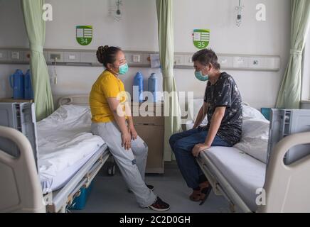 (200617) -- WUHAN, 17 juin 2020 (Xinhua) -- Hu Dingjiang attend d'être libéré de l'hôpital avec sa femme dans un quartier de l'hôpital pulmonaire de Wuhan à Wuhan, dans la province de Hubei, en Chine centrale, le 17 juin 2020. Hu Dingjiang, 40 ans, un patient COVID-19 retrouvé, a quitté l'hôpital pulmonaire de Wuhan mercredi après avoir reçu un traitement médical et une formation de réadaptation pendant plus de 100 jours. Il a reçu un diagnostic de maladie début février et a été hospitalisé dans le service de soins intensifs comme l'un des 81 cas graves de COVID-19 à l'hôpital. Les fonctions de ses poumons ont récupéré le 5 avril avec 4 Banque D'Images