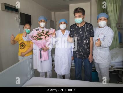 (200617) -- WUHAN, 17 juin 2020 (Xinhua) -- Hu Dingjiang (2e, R) et son épouse (1er, L) posent pour une photo de groupe avec des travailleurs médicaux dans une salle de l'hôpital pulmonaire de Wuhan à Wuhan, dans la province de Hubei, en Chine centrale, le 17 juin 2020. Hu Dingjiang, 40 ans, un patient COVID-19 retrouvé, a quitté l'hôpital pulmonaire de Wuhan mercredi après avoir reçu un traitement médical et une formation de réadaptation pendant plus de 100 jours. Il a reçu un diagnostic de maladie début février et a été hospitalisé dans le service de soins intensifs comme l'un des 81 cas graves de COVID-19 à l'hôpital. Les fonctions de ses poumons se rétablissent Banque D'Images