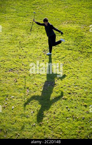 Vue aérienne d'un golfeur avec succès tenant le club de golf et le ballon et debout sur une jambe sur le Fairway avec ombre. Banque D'Images