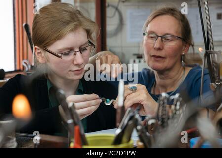 17 juin 2020, Thuringe, Gotha: L'apprenti Ulrike Niewiadoma (l, 3e année d'apprentissage) de l'entreprise artisanale 'Gold- und Platinschmiede Kerstin Damm' saisit un pendentif sous les instructions du propriétaire. Le forgeron reçoit la première subvention de formation pour les apprentis de l'État libre de Thuringe, qui est destinée à compenser l'allocation de formation complète qui continuera d'être versée pendant la crise de Corona. Photo: Michael Reichel/dpa-Zentralbild/dpa Banque D'Images