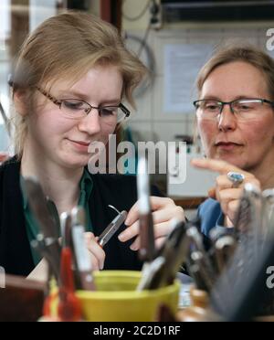 17 juin 2020, Thuringe, Gotha: L'apprenti Ulrike Niewiadoma (l, 3e année d'apprentissage) de l'entreprise artisanale 'Gold- und Platinschmiede Kerstin Damm' saisit un pendentif sous les instructions du propriétaire. Le forgeron reçoit la première subvention de formation pour les apprentis de l'État libre de Thuringe, qui est destinée à compenser l'allocation de formation complète qui continuera d'être versée pendant la crise de Corona. Photo: Michael Reichel/dpa-Zentralbild/dpa Banque D'Images