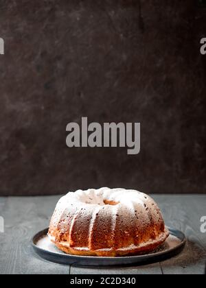 Saupoudrer le sucre glace à la main sur le gâteau au muffin Banque D'Images