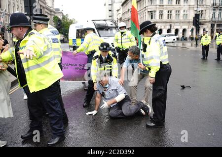 La police a arrêté un homme après qu'il s'est présenté devant la voiture du Premier ministre Boris Johnson alors qu'il quittait le Parlement, Westminster. L'homme, qui manifestait au sujet de l'opération de la Turquie contre les rebelles kurdes dans le nord de l'Irak, a été emmené au Palais de Westminster par des officiers. Banque D'Images