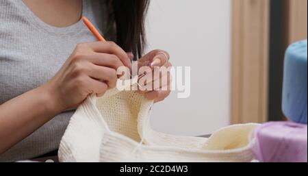 Femme triant avec crochet crochet et fil de crochet à la maison Banque D'Images