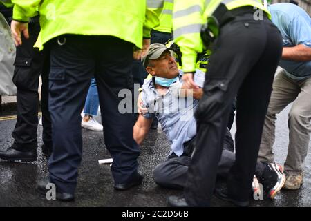 La police a arrêté un homme après qu'il s'est présenté devant la voiture du Premier ministre Boris Johnson alors qu'il quittait le Parlement, Westminster. L'homme, qui manifestait au sujet de l'opération de la Turquie contre les rebelles kurdes dans le nord de l'Irak, a été emmené au Palais de Westminster par des officiers. Banque D'Images