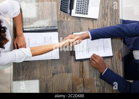 Young Businesspeople Shaking Hands At Interview in Office Banque D'Images