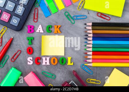 L'acheminement de fournitures scolaires sur un fond gris foncé. La vue du sommet. Mise à plat Banque D'Images