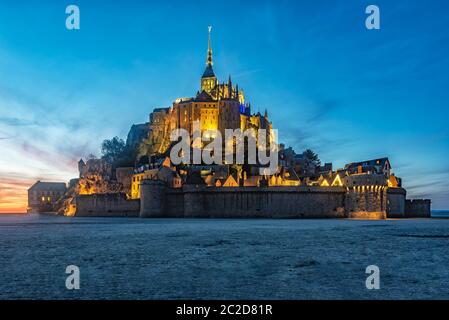 Coucher du soleil sur le Mont Saint Michel avec un bel éclairage d'un lampadaire. Banque D'Images