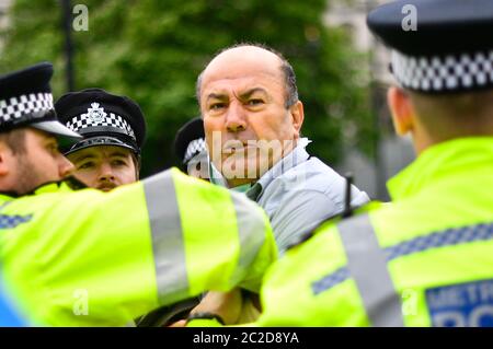 La police a arrêté un homme après qu'il s'est présenté devant la voiture du Premier ministre Boris Johnson alors qu'il quittait le Parlement, Westminster. L'homme, qui manifestait au sujet de l'opération de la Turquie contre les rebelles kurdes dans le nord de l'Irak, a été emmené au Palais de Westminster par des officiers. Banque D'Images