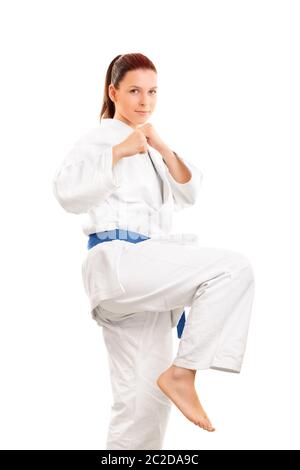 Le portrait d'une belle jeune fille en kimono avec une ceinture bleu pour préparer un coup de pied, isolé sur fond blanc. Banque D'Images