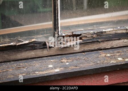 Détail du cadre en bois d'une ancienne fenêtre avec bois pourri et peinture écaillée. Banque D'Images