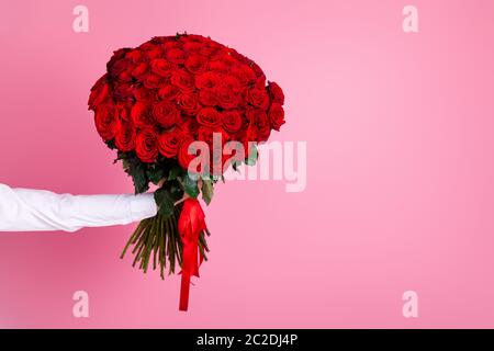 Photo de l'homme court bras tenir grand cent rouge roses rouges bouquet de donner à petite amie surprise ne pas montrer visage secret admirer la livraison d'arrangement Banque D'Images