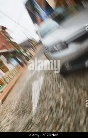 Image floue de courir à travers la route environ à par une voiture, tombant en face de lui Banque D'Images