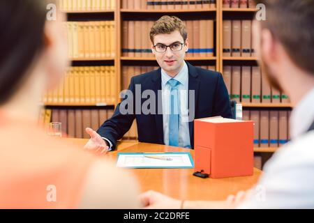 Notaire conseillant le couple sur le mariage dans son bureau Banque D'Images