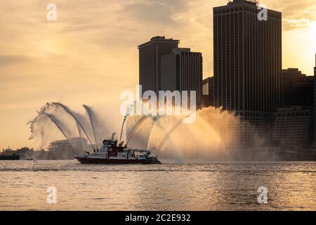 Le bateau FDNY pulvérise de l'eau rouge, blanche et bleue avant le feu d'artifice du 4 juillet de Macy Banque D'Images