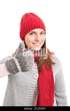 Beautiful smiling young girl in winter clothes holding Thumbs up, isolé sur fond blanc. Banque D'Images