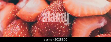 Close-up de fraises en tranches. Fond rouge brillant Banque D'Images