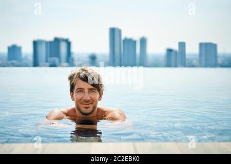 Un homme charmant se détendre dans la piscine Banque D'Images