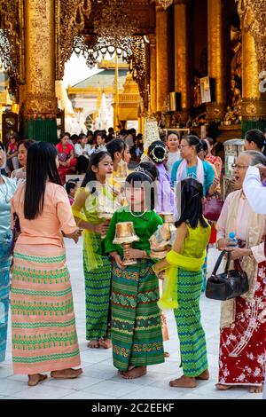 Les enfants aux couleurs vives prennent part à UNE cérémonie de Noviciation/Shinbyu à la Pagode Shwedagon, Yangon, Myanmar. Banque D'Images