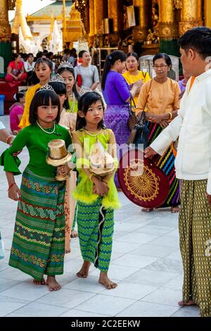 Les enfants aux couleurs vives prennent part à UNE cérémonie de Noviciation/Shinbyu à la Pagode Shwedagon, Yangon, Myanmar. Banque D'Images