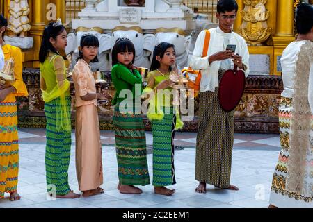 Les enfants aux couleurs vives prennent part à UNE cérémonie de Noviciation/Shinbyu à la Pagode Shwedagon, Yangon, Myanmar. Banque D'Images