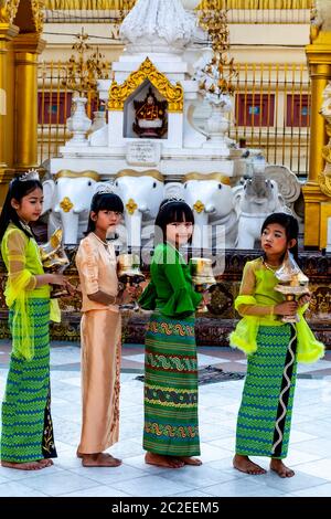 Les enfants aux couleurs vives prennent part à UNE cérémonie de Noviciation/Shinbyu à la Pagode Shwedagon, Yangon, Myanmar. Banque D'Images