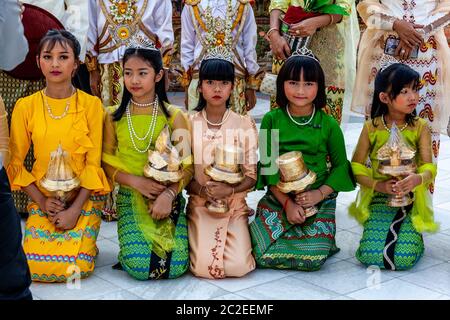 Les enfants aux couleurs vives prennent part à UNE cérémonie de Noviciation/Shinbyu à la Pagode Shwedagon, Yangon, Myanmar. Banque D'Images