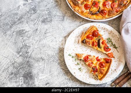 Quiche végétarienne tarte faite maison, avec des tomates cerises, aubergines et fromage feta sur un fond clair/ Banque D'Images