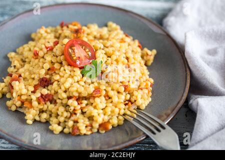 Ptitim ou Birdy, couscous pâtes israéliennes avec tomates et fines herbes/ Banque D'Images