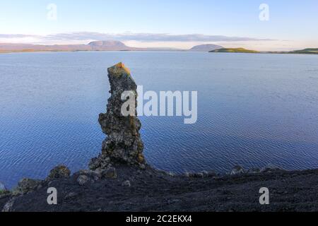 Un pilier de lave typique sur les rives du lac Myvatn, en Islande avec une toile de fond de la montagne Blafjall (1222m). Banque D'Images