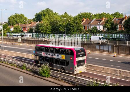 Un Metrobus Bristol traverse les quartiers d'Easton et de St Werburghs du centre-ville de Bristol, en passant par un grand climat peint chan Banque D'Images