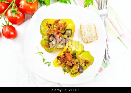 Poivron farci aux champignons, tomates, courgettes, aubergines et oignons, assaisonnés avec du vin, l'ail, le thym et les épices en cuisine sur plaque blanche t Banque D'Images