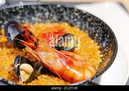 Paella de Valence avec riz, safran et fruits de mer servis dans une casserole spéciale. Banque D'Images