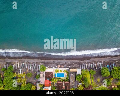 Vue aérienne de la plage d'Amed à Bali, Indonésie. Bateaux de pêche traditionnelles appelées jukung sur la plage de sable noir. Banque D'Images