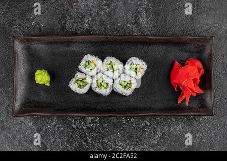 Rouleau de riz, de nori et de concombre kappa maki japonais sur fond noir Banque D'Images