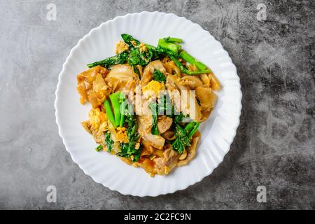 Sauté de nouilles de farine de riz frais avec des tranches de porc, d'oeufs et de chou frisé. Sauté de nouilles rapide. Banque D'Images