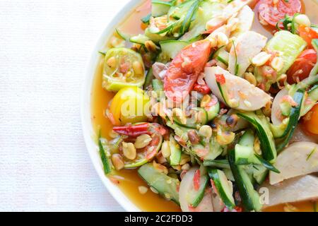 Salade de concombre avec saucisses de porc conservées, nourriture populaire thaïlandaise appelée Som Tum Tang, légumes chauds et épicés, mélangés. Banque D'Images