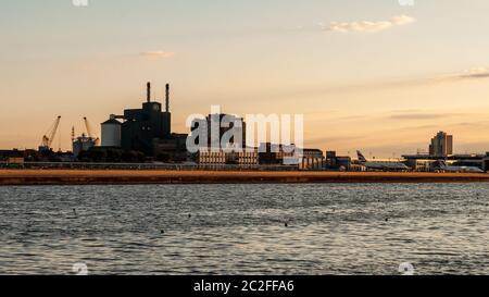 Londres, Angleterre, Royaume-Uni - 31 juillet 2010 : des avions attendent à l'aéroport de London City sur Royal Albert Dock, avec le coucher de soleil qui illumine le Tate & LYL Banque D'Images