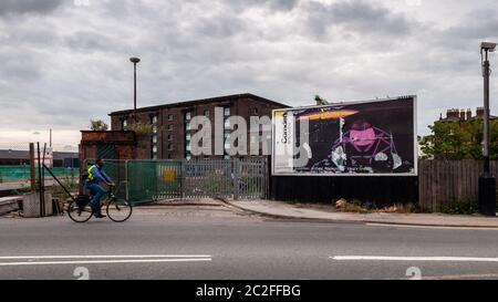 Londres, Angleterre, Royaume-Uni - 13 juillet 2010 : un cycliste passe devant un panneau d'affichage délabré et un terrain de gaspillage derrière la gare de King's Cross pendant la régénération du G Banque D'Images