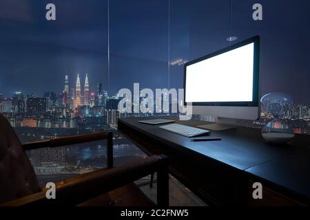 Ordinateur de bureau avec vue sur la ville de Kuala Lumpur au crépuscule. Banque D'Images