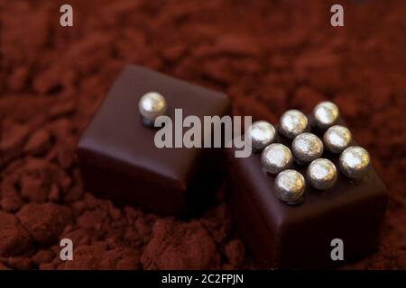 Gros plan de pralines au chocolat précieuses en poudre de cacao Banque D'Images