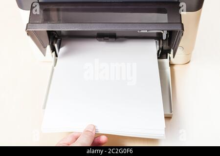 Mettre des feuilles de papier blanc dans le bac de l'imprimante multi fonctions appareil sur table Banque D'Images