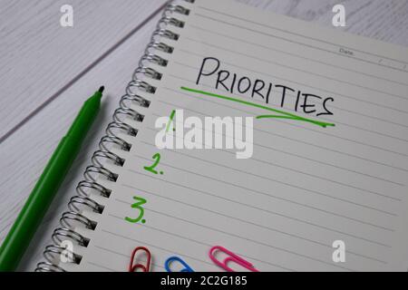 Les priorités sont à noter sur un pense-bête. Supporté par une table en bois isolée de services supplémentaires. Banque D'Images