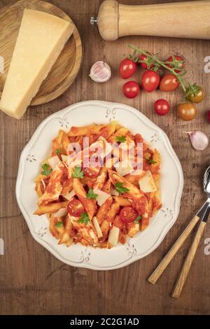 Penne avec sauce au poulet et à la tomate, prise ci-dessus avec ingrédients, parmesan, tomates, poivre et gousses d'ail, on Banque D'Images