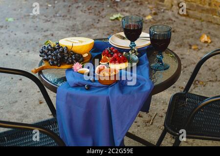 Petite table de café de rue. Sur la table sont des verres de vin et de la nourriture. Le concept de distance pendant la quarantaine. Banque D'Images