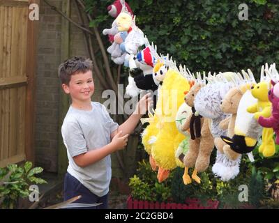 Un enfant aussi joyeux et joyeux - plein de jouets doux lavés et séchant sur la ligne de lavage pour la foire d'été de l'école - très mignon Banque D'Images